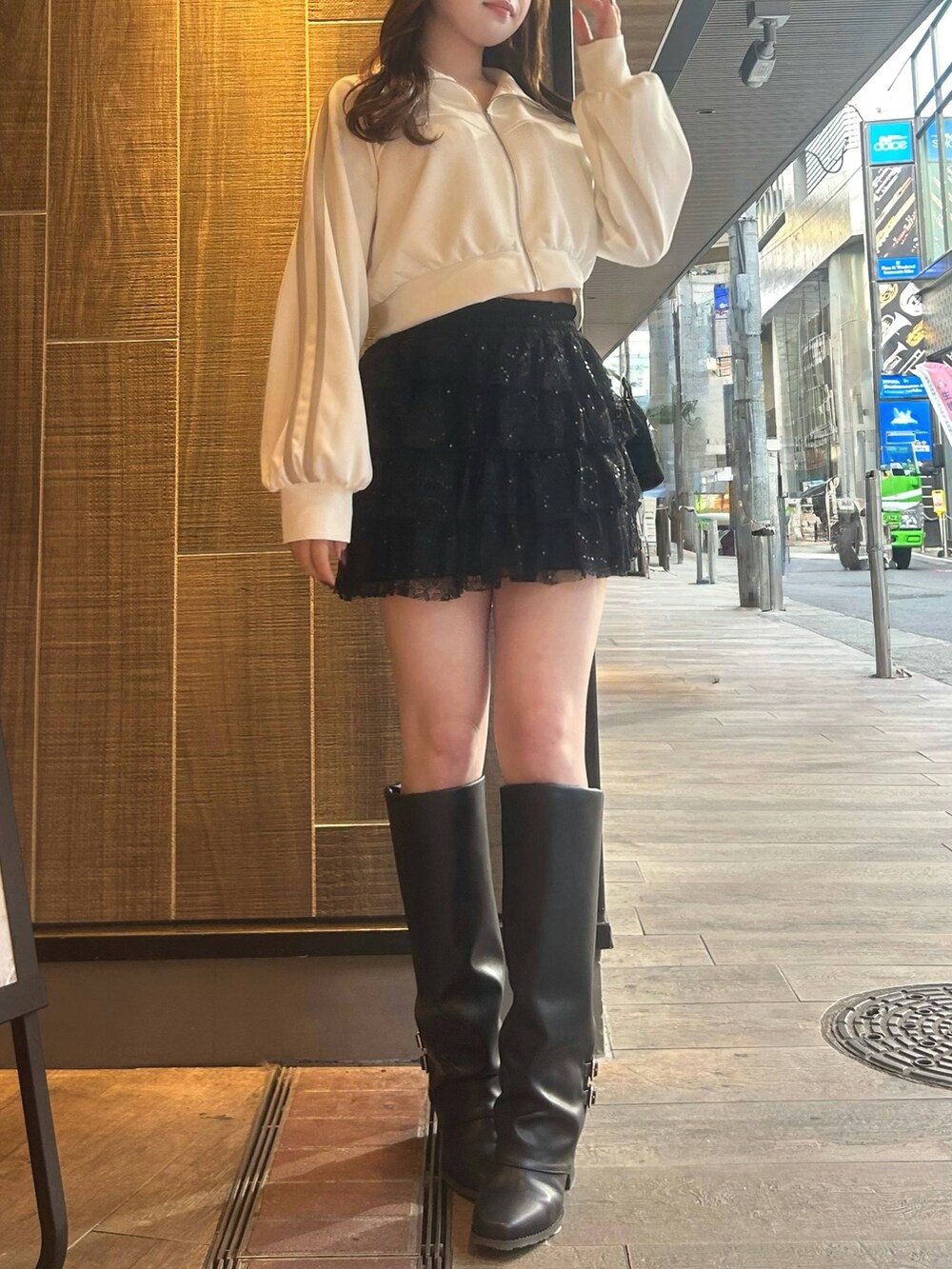 ブラック系のその他パンツ、ホワイト系のその他アウター、ブラック系のブーツを着用したレディースの冬コーディネートの2枚目の写真