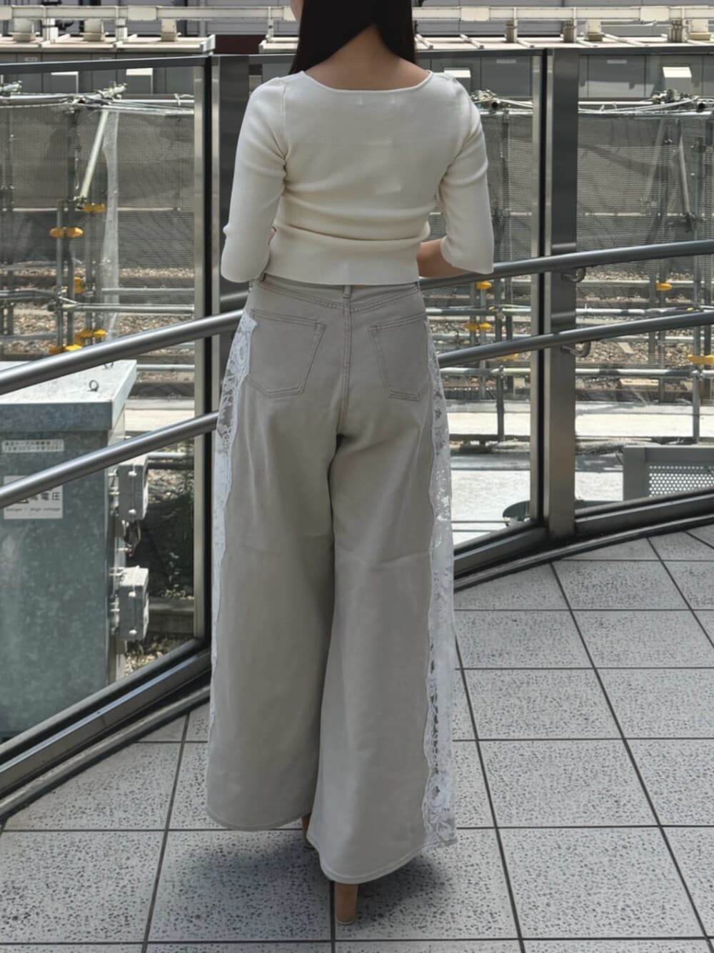 ホワイト系のニット/セーター、ベージュ系のデニムパンツ、ホワイト系のサンダルを着用したレディースの夏コーディネートの3枚目の写真