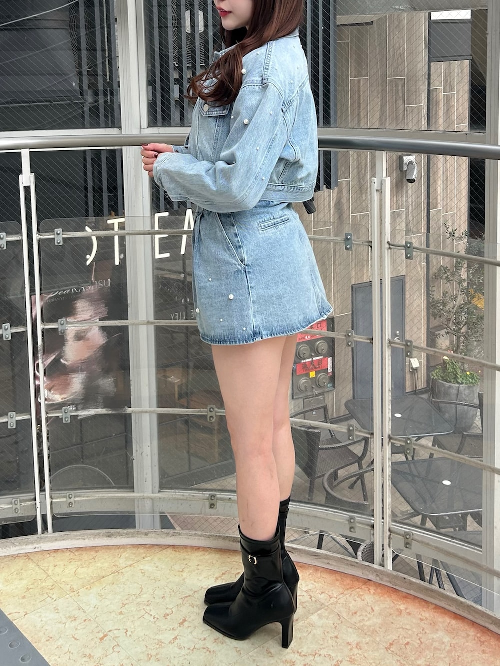 ブルー系のデニムジャケット、ブルー系のデニムパンツ、ブラック系のブーツを着用したレディースの冬コーディネートの3枚目の写真