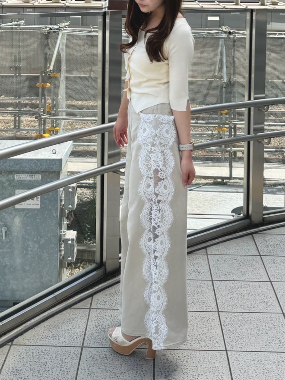 ホワイト系のニット/セーター、ベージュ系のデニムパンツ、ホワイト系のサンダルを着用したレディースの夏コーディネートの2枚目の写真