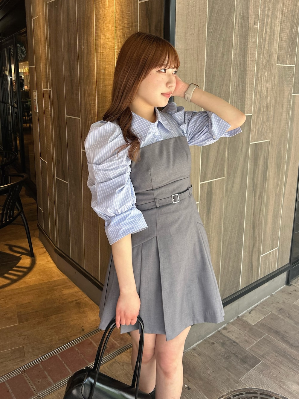 グレー系のワンピース、ブラック系のハンドバッグ、ブラック系のブーツを着用したレディースの春コーディネートの4枚目の写真