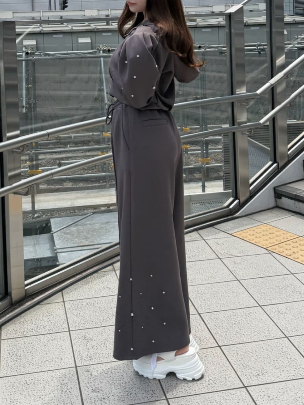 ブラウン系のTシャツ/カットソー、ブラウン系のスウェットパンツ、ホワイト系のサンダルを着用したレディースの夏コーディネートの3枚目の写真