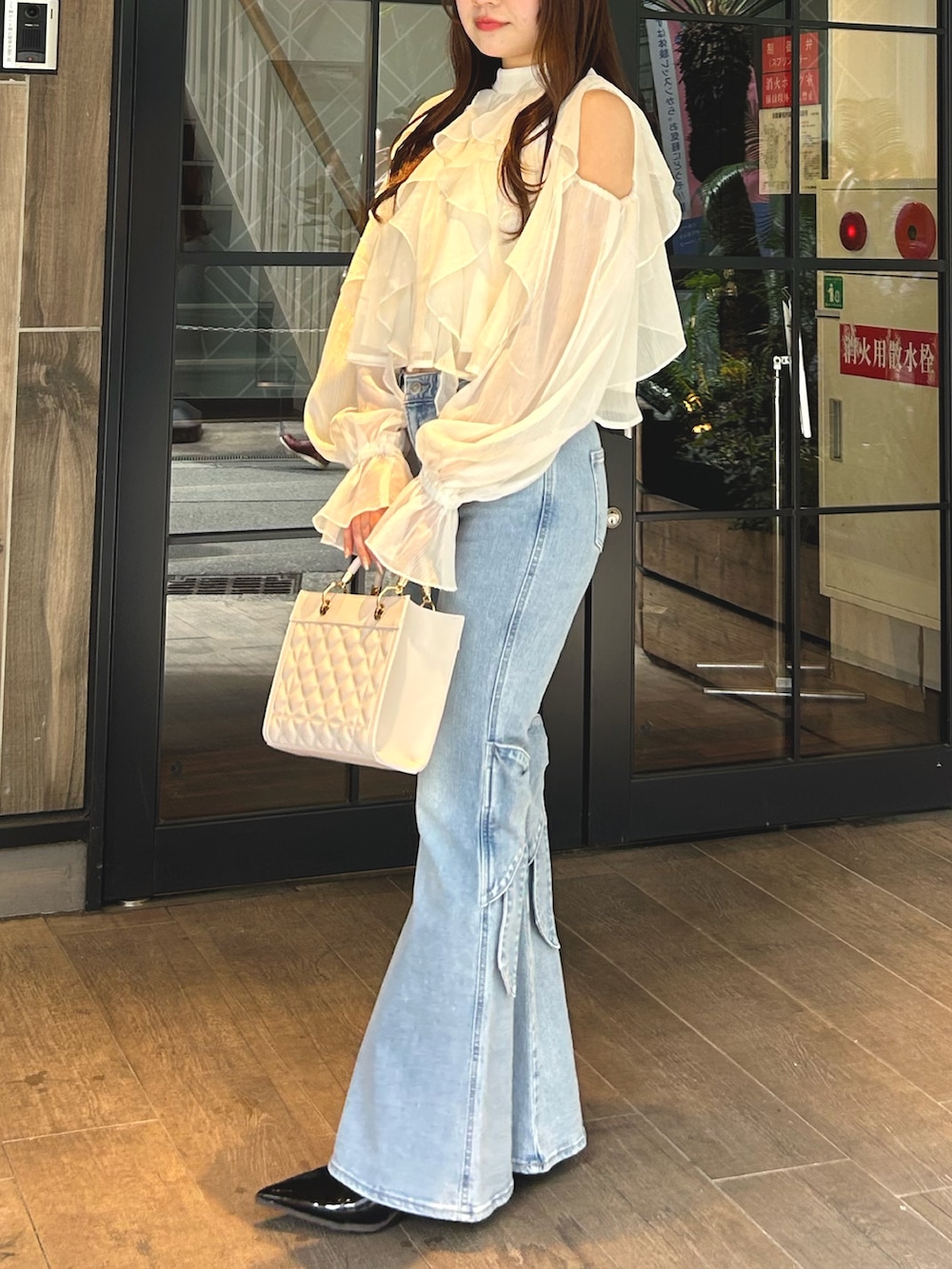 ホワイト系のシャツ/ブラウス、ブルー系のデニムパンツ、ブラック系のパンプスを着用したレディースの春コーディネートの2枚目の写真