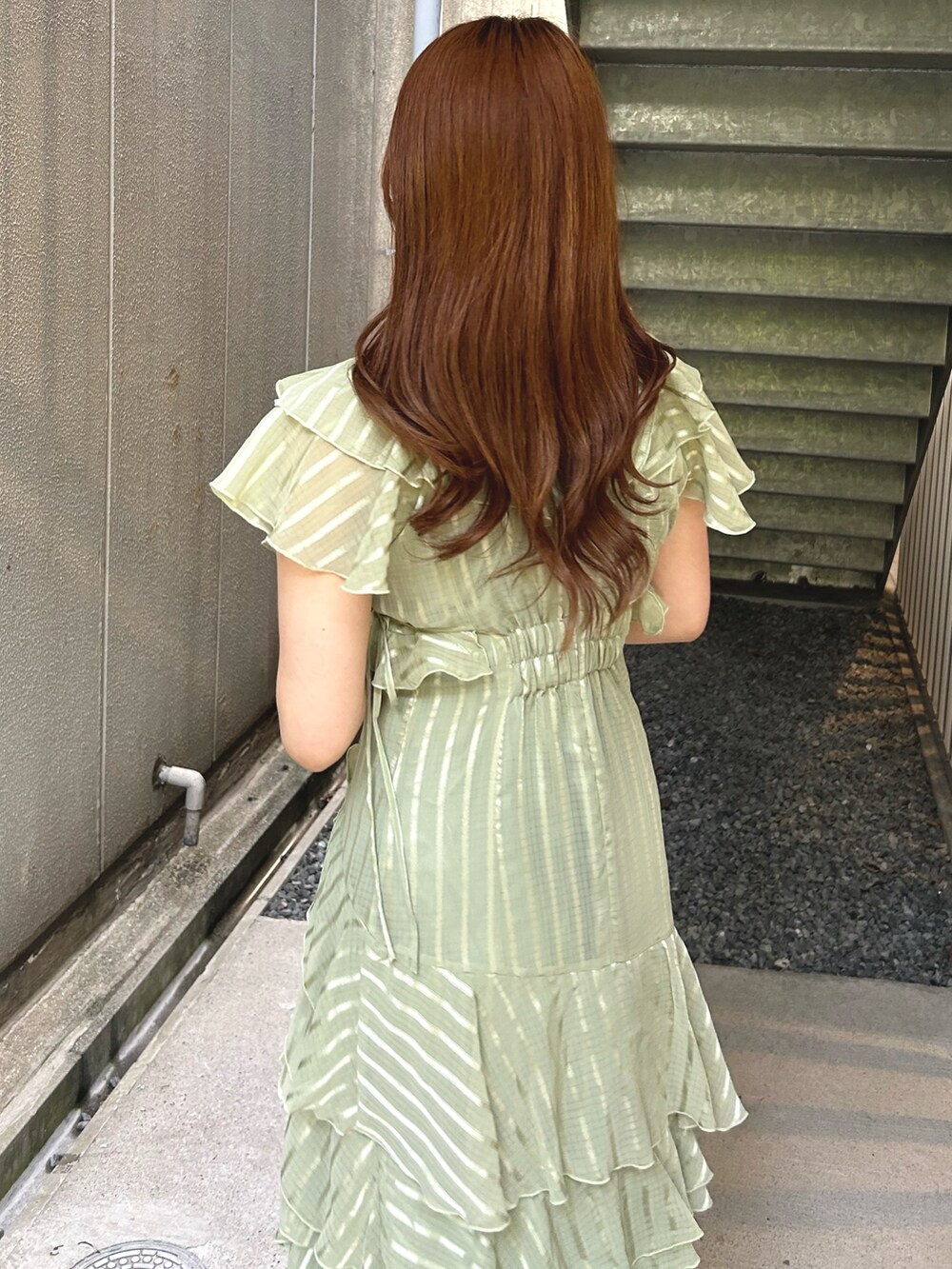 グリーン系のワンピース、ブラウン系のローファーを着用したレディースの春コーディネートの4枚目の写真