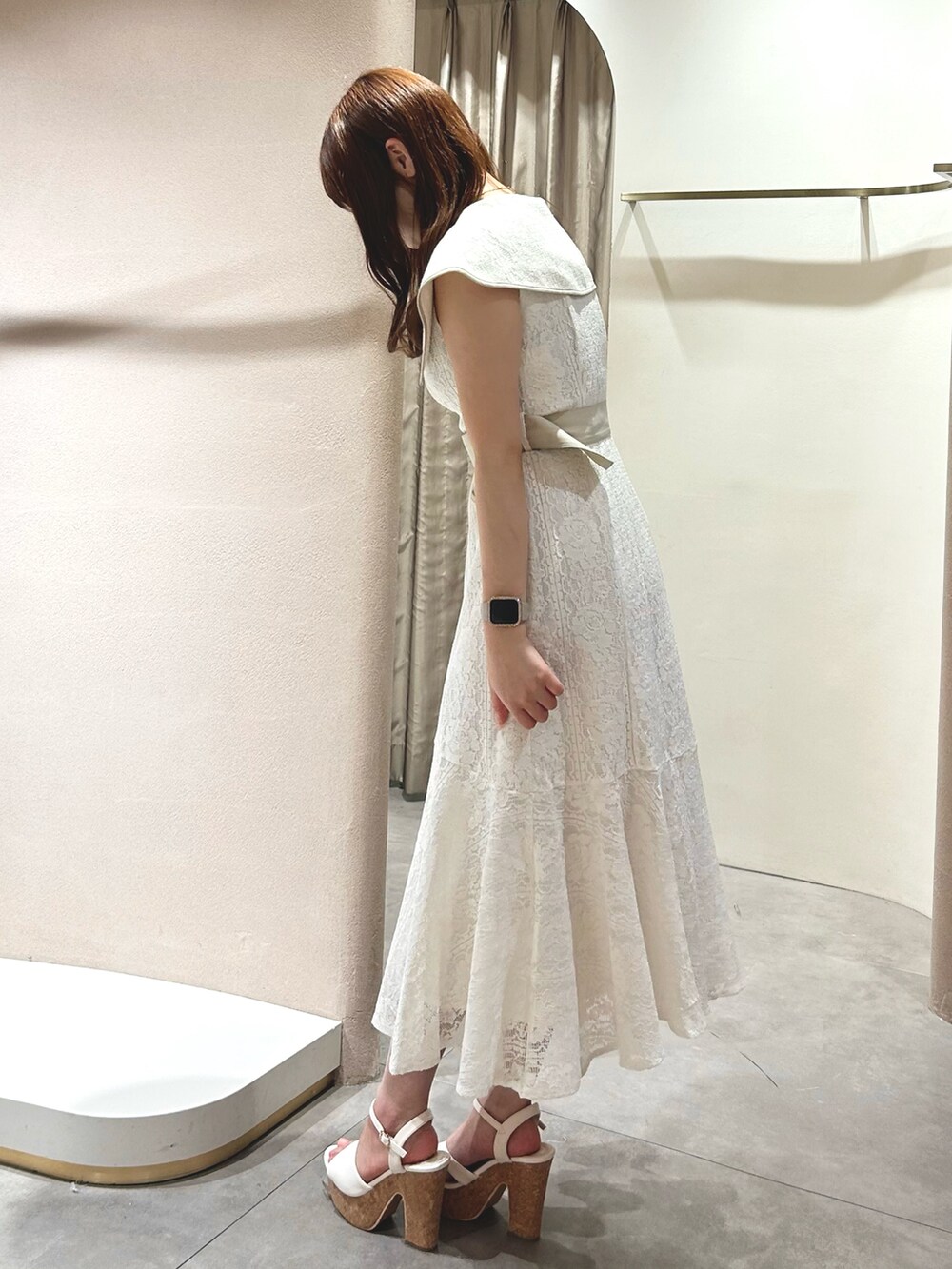 ホワイト系のワンピース、ホワイト系のサンダル、ブラック系のかごバッグを着用したレディースの春コーディネートの5枚目の写真