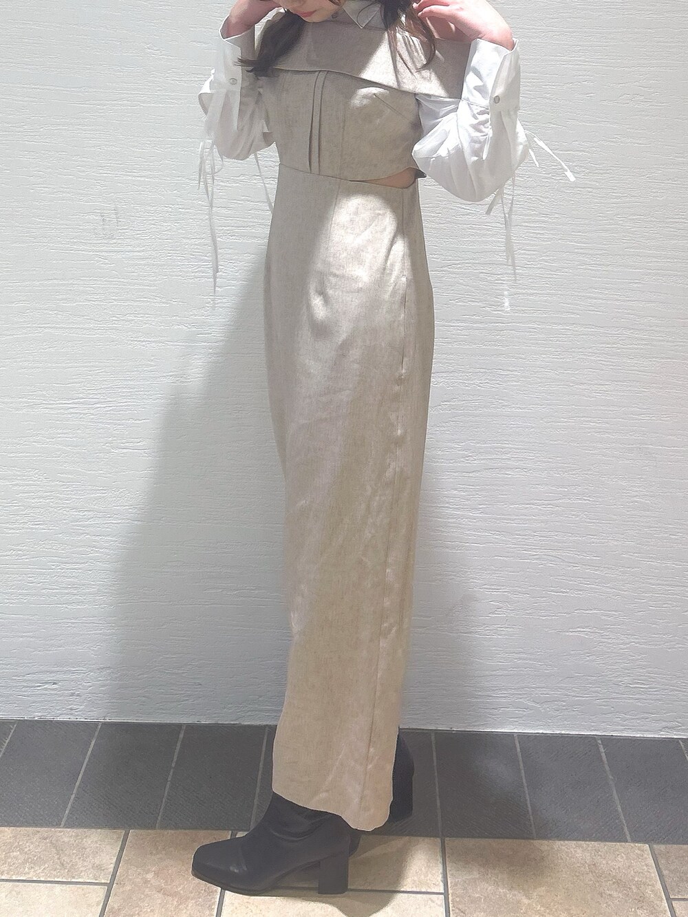 ベージュ系のワンピースを着用したレディースの冬コーディネートの4枚目の写真