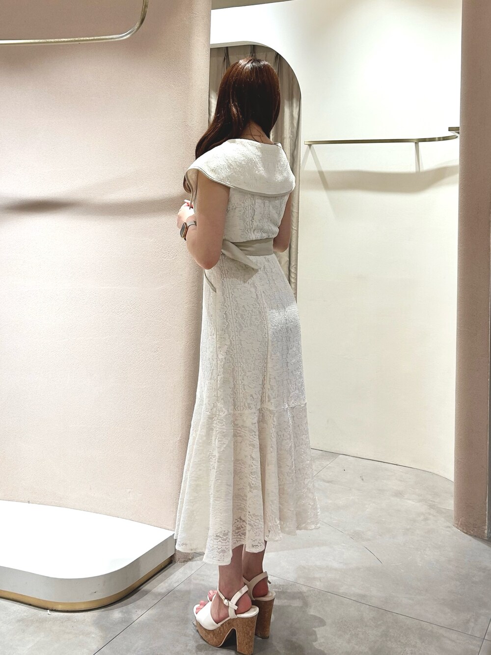 ホワイト系のワンピース、ホワイト系のサンダル、ブラック系のかごバッグを着用したレディースの春コーディネートの6枚目の写真