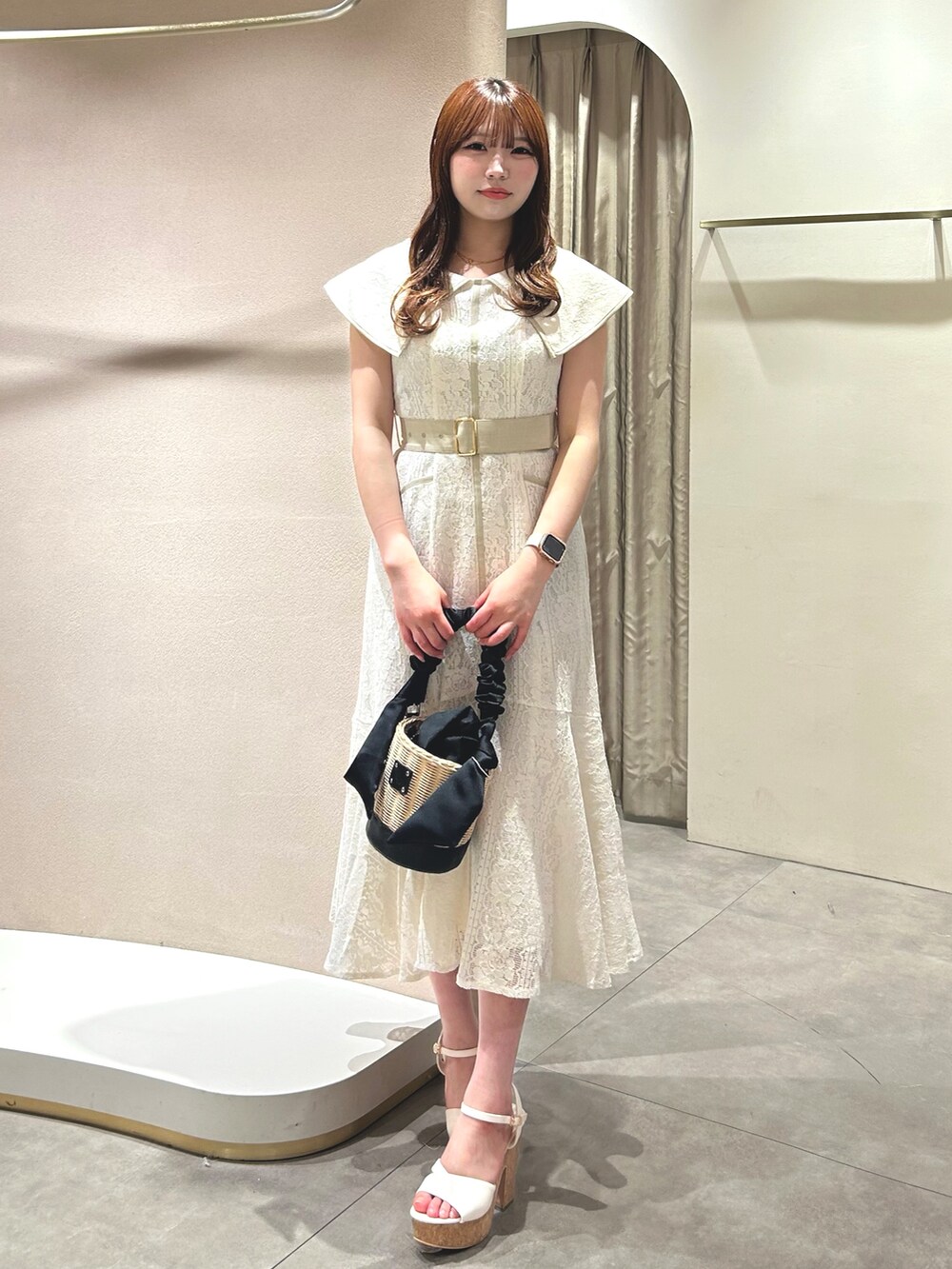 ホワイト系のワンピース、ホワイト系のサンダル、ブラック系のかごバッグを着用したレディースの春コーディネートの4枚目の写真