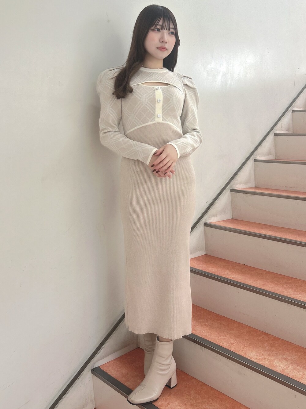 ベージュ系のワンピースを着用したレディースの冬コーディネートの2枚目の写真