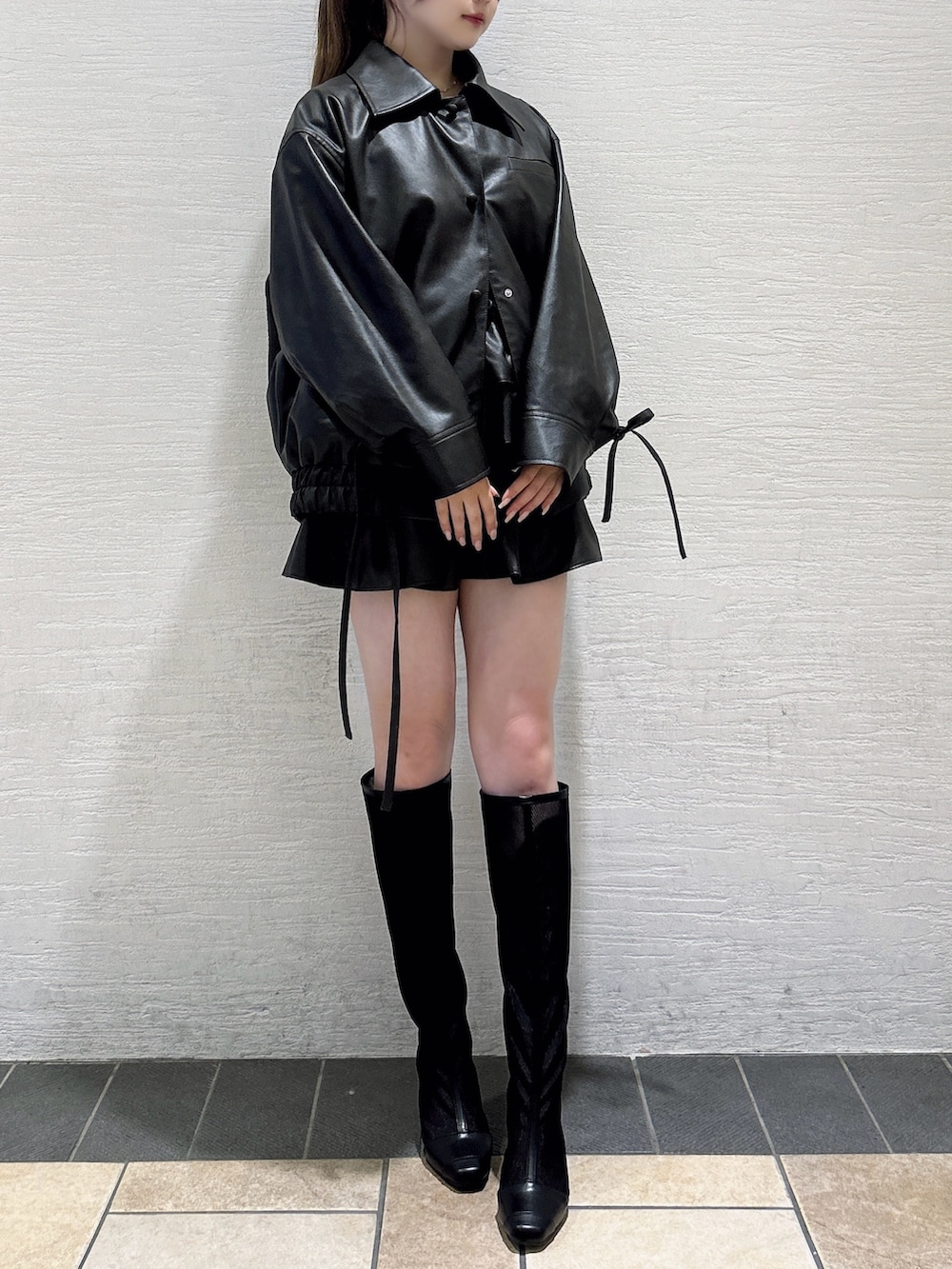 ブラウン系のスカート、ブラウン系のブルゾン、ホワイト系のTシャツ/カットソーを着用したレディースの秋コーディネートの2枚目の写真