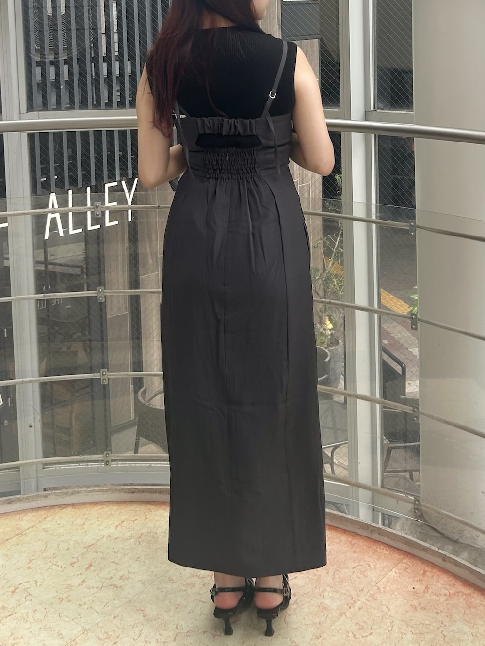 グレー系のワンピース、ブラック系のパンプス、ブラック系のニット/セーターを着用したレディースの夏コーディネートの3枚目の写真