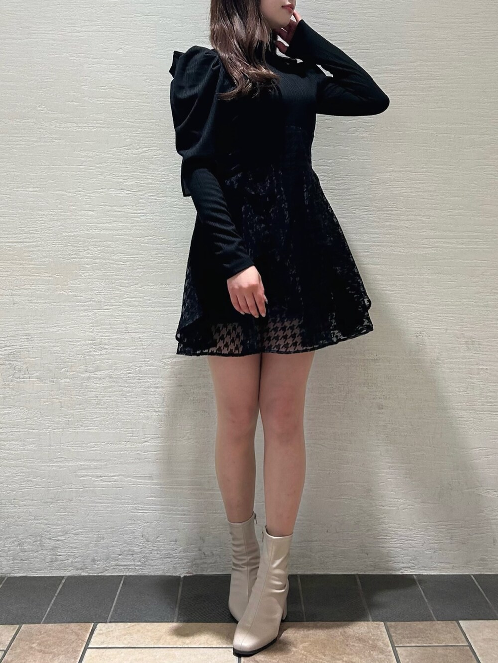 ブラック系のワンピース、ベージュ系のブーツを着用したレディースの秋コーディネートの2枚目の写真