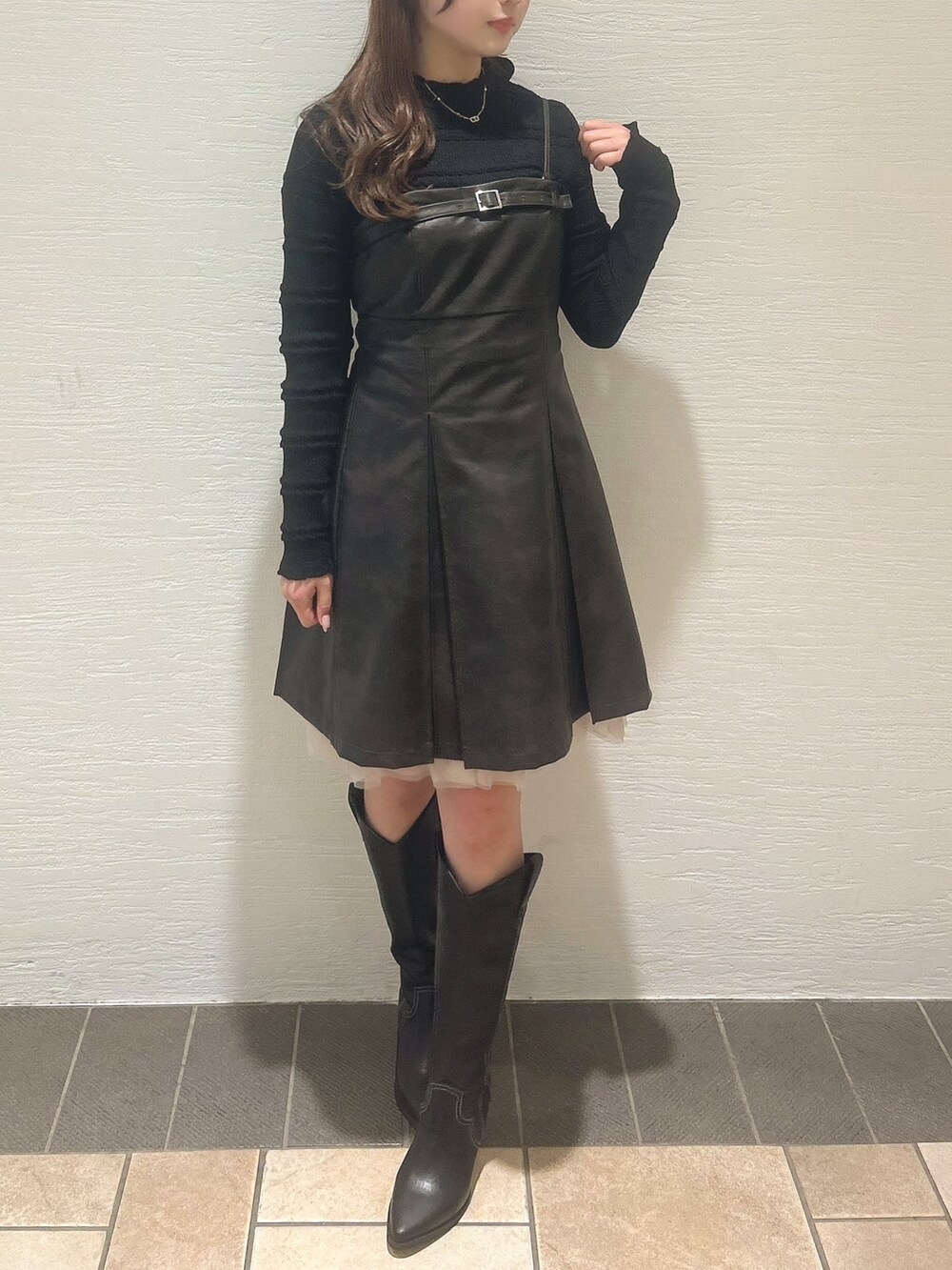 ブラウン系のワンピース、ブラック系のニット/セーター、その他のブーツを着用したレディースの冬コーディネートの3枚目の写真