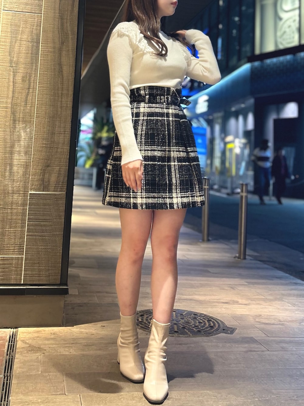 ブラック系のスカート、ホワイト系のニット/セーターを着用したレディースの秋コーディネートの2枚目の写真