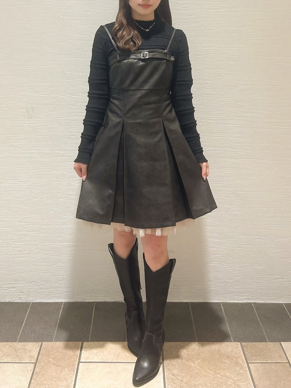 ブラウン系のワンピース、ブラック系のニット/セーター、その他のブーツを着用したレディースの冬コーディネートの2枚目の写真