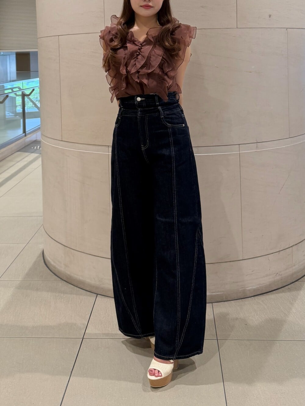 ブルー系のデニムパンツ、ホワイト系のサンダル、ブラウン系のシャツ/ブラウスを着用したレディースの夏コーディネートの4枚目の写真