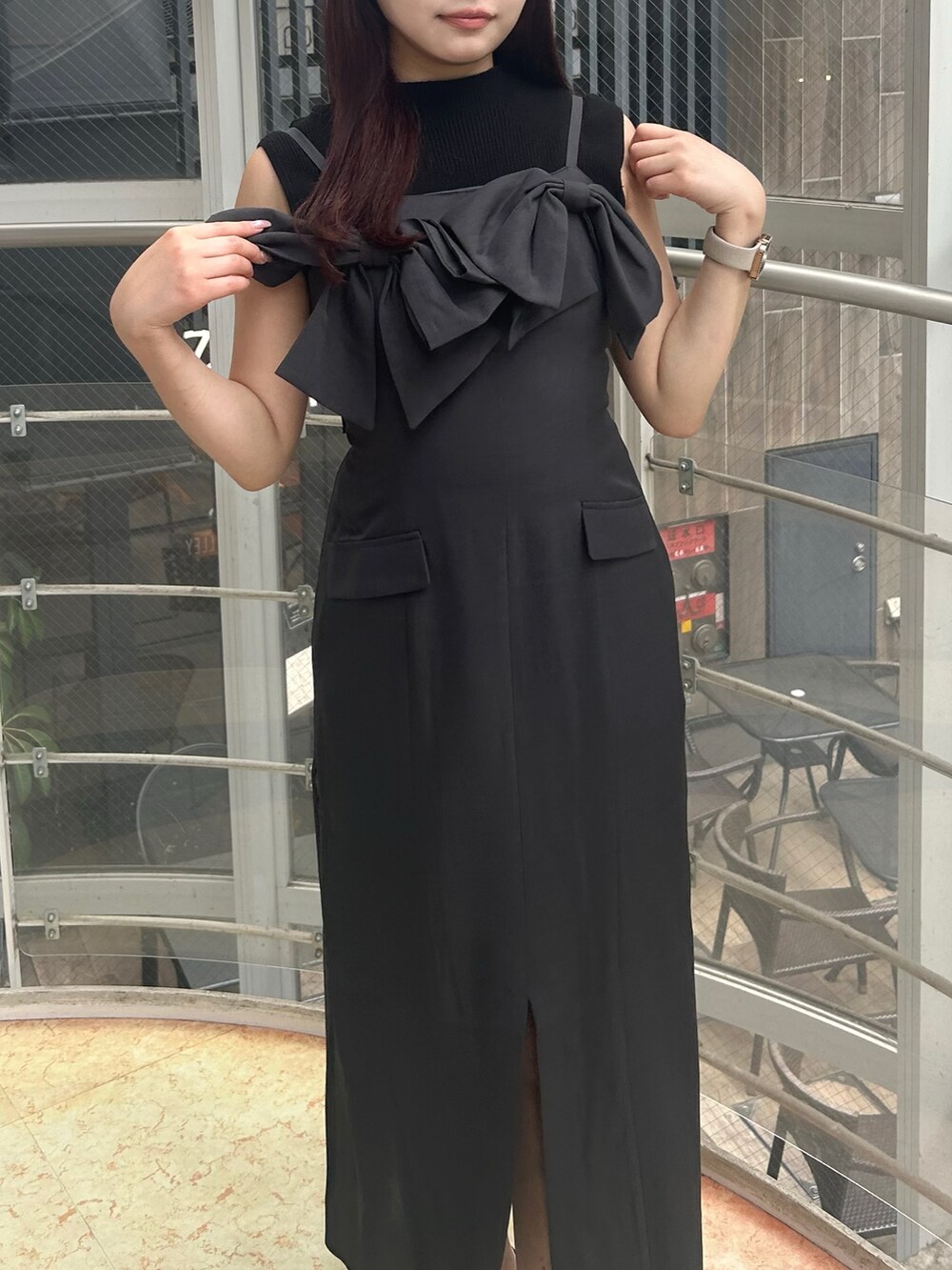 グレー系のワンピース、ブラック系のパンプス、ブラック系のニット/セーターを着用したレディースの夏コーディネートの4枚目の写真