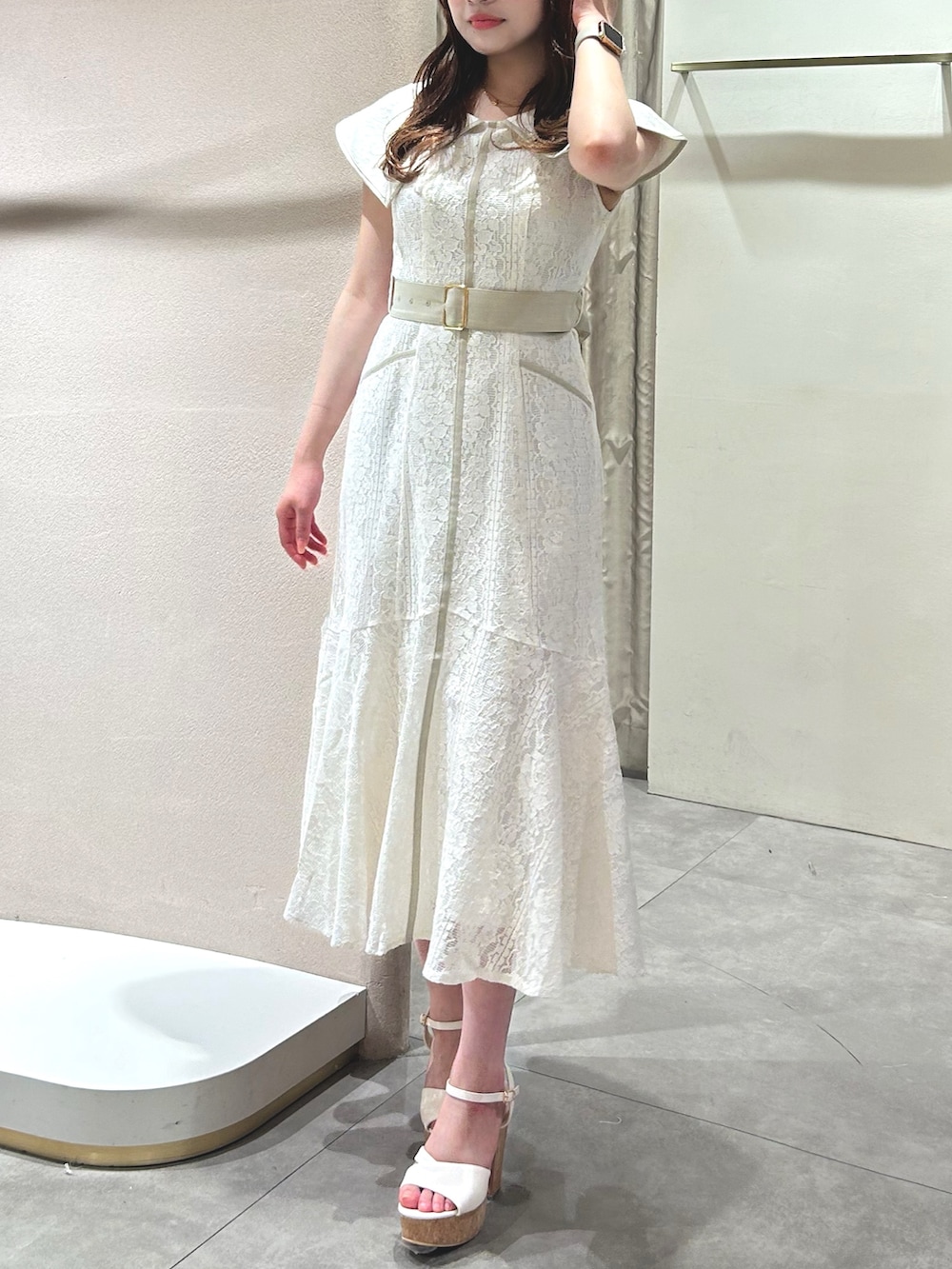 ホワイト系のワンピース、ホワイト系のサンダル、ブラック系のかごバッグを着用したレディースの春コーディネートの3枚目の写真