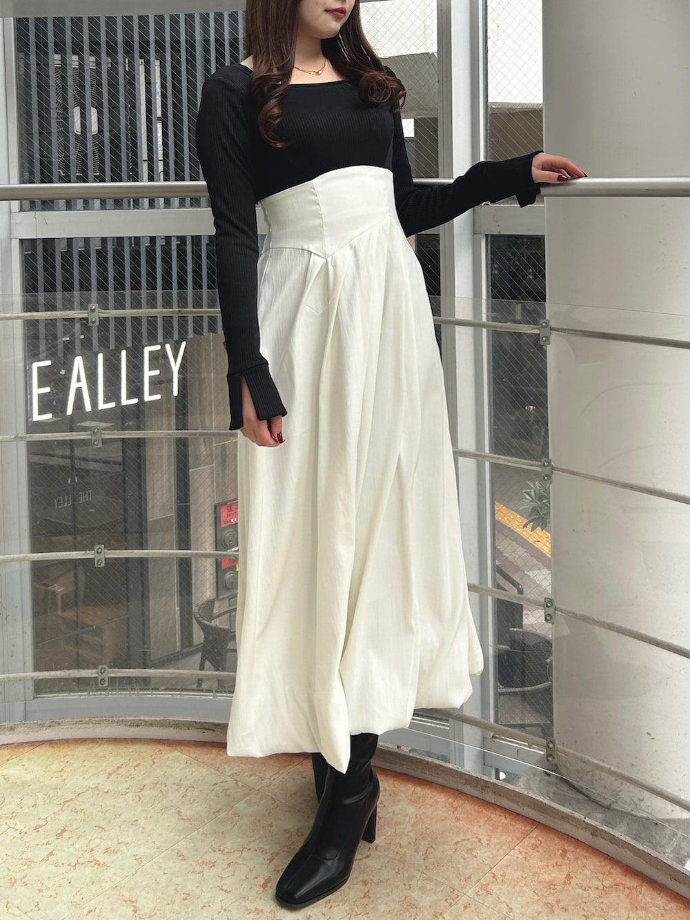 ブラック系のワンピース、ブラック系のブーツを着用したレディースの冬コーディネートの2枚目の写真