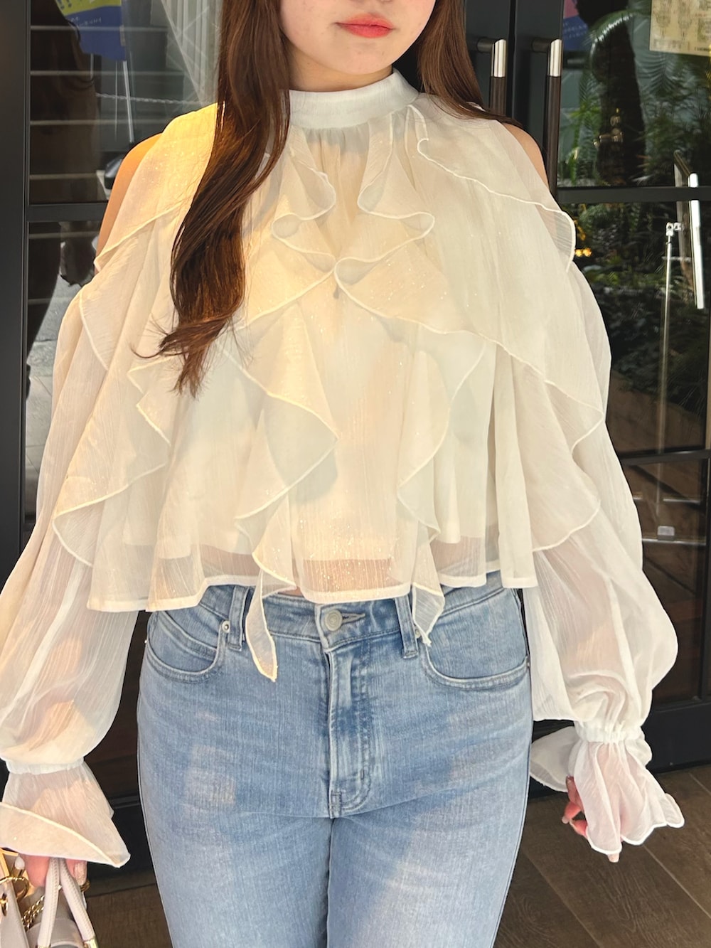 ホワイト系のシャツ/ブラウス、ブルー系のデニムパンツ、ブラック系のパンプスを着用したレディースの春コーディネートの5枚目の写真