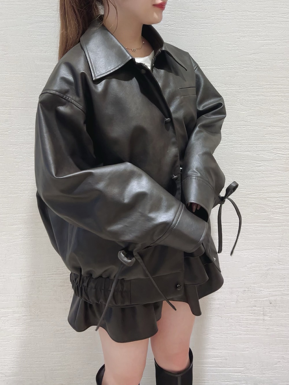 ブラウン系のスカート、ブラウン系のブルゾン、ホワイト系のTシャツ/カットソーを着用したレディースの秋コーディネートの4枚目の写真