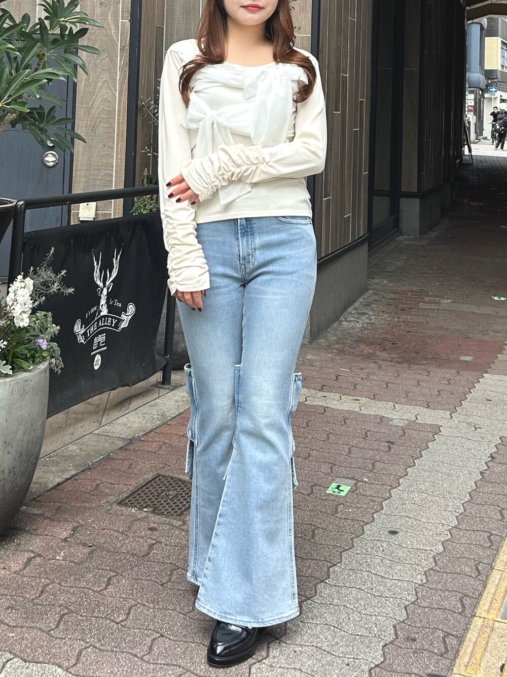 イエロー系のTシャツ/カットソー、ブルー系のデニムパンツ、ブラック系のパンプスを着用したレディースの春コーディネートの2枚目の写真