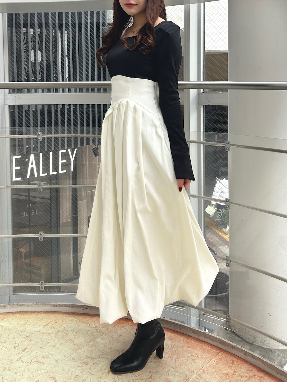 ブラック系のワンピース、ブラック系のブーツを着用したレディースの冬コーディネートの3枚目の写真