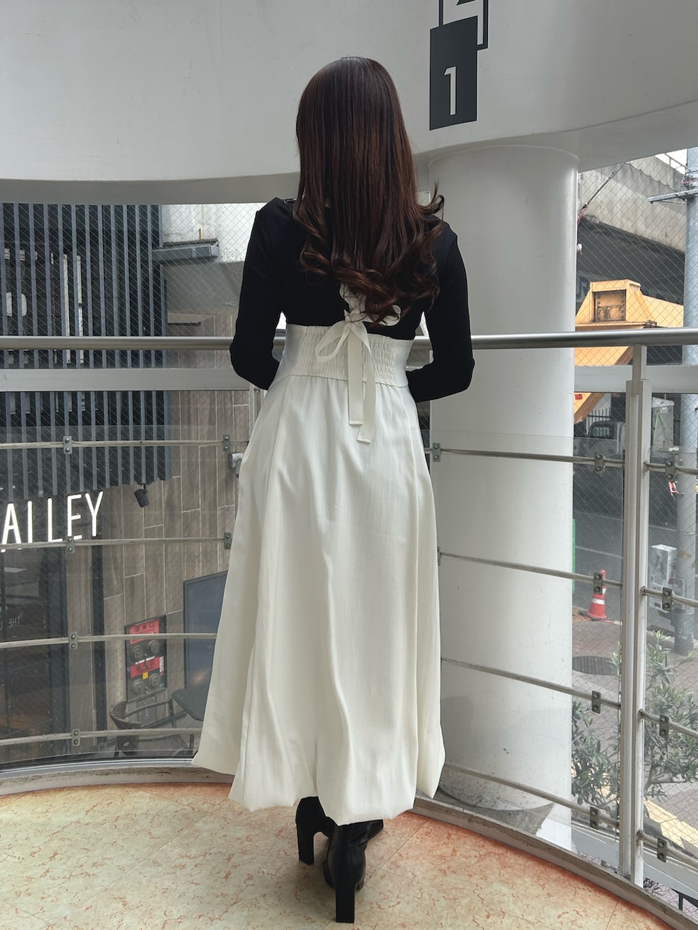 ブラック系のワンピース、ブラック系のブーツを着用したレディースの冬コーディネートの4枚目の写真