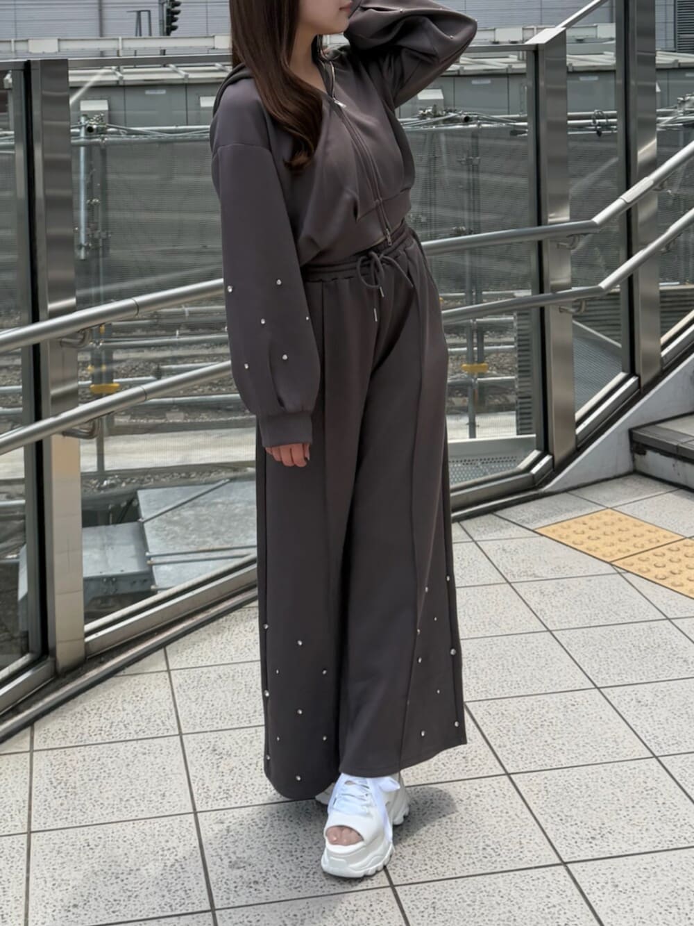ブラウン系のTシャツ/カットソー、ブラウン系のスウェットパンツ、ホワイト系のサンダルを着用したレディースの夏コーディネートの2枚目の写真