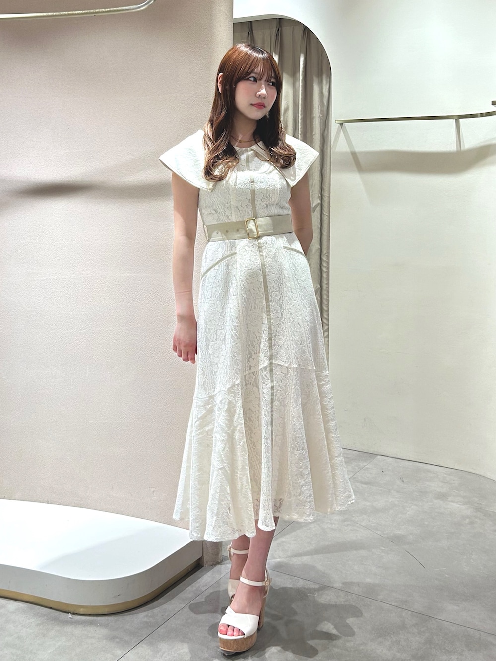 ホワイト系のワンピース、ホワイト系のサンダル、ブラック系のかごバッグを着用したレディースの春コーディネートの2枚目の写真