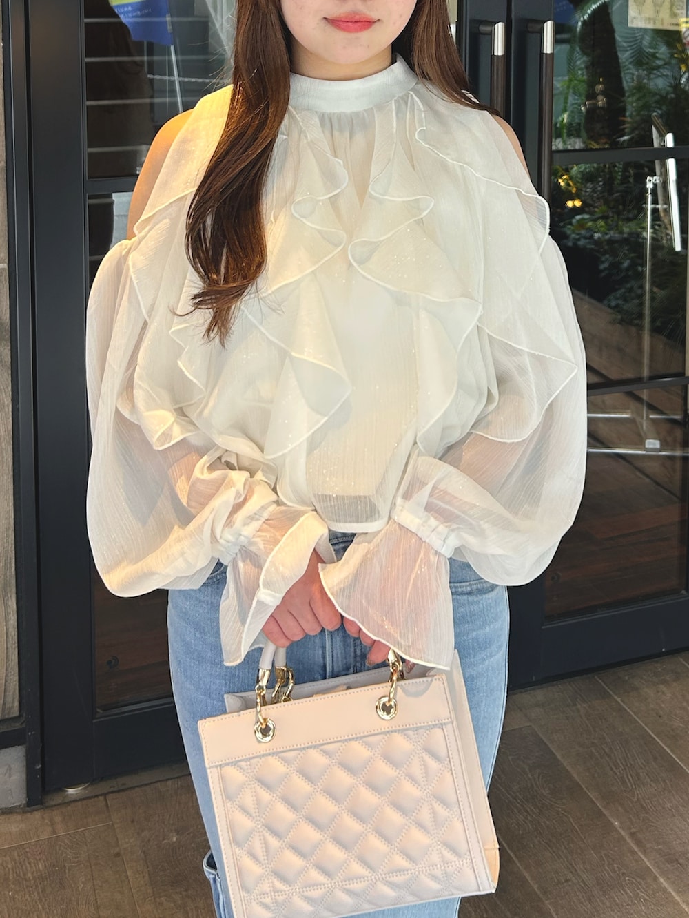 ホワイト系のシャツ/ブラウス、ブルー系のデニムパンツ、ブラック系のパンプスを着用したレディースの春コーディネートの4枚目の写真