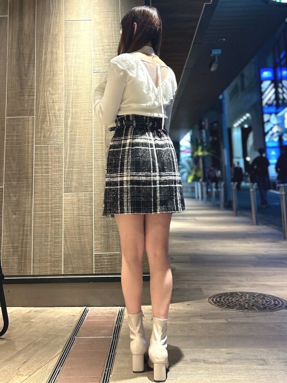 ブラック系のスカート、ホワイト系のニット/セーターを着用したレディースの秋コーディネートの3枚目の写真