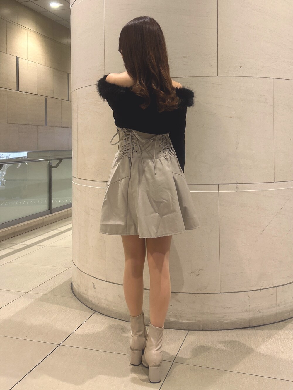 ベージュ系のスカート、ブラック系のニット/セーターを着用したレディースの冬コーディネートの3枚目の写真