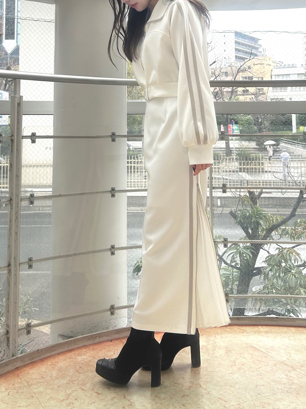 ホワイト系のその他アウター、ホワイト系のスカート、ブラック系のブーツを着用したレディースの春コーディネートの3枚目の写真