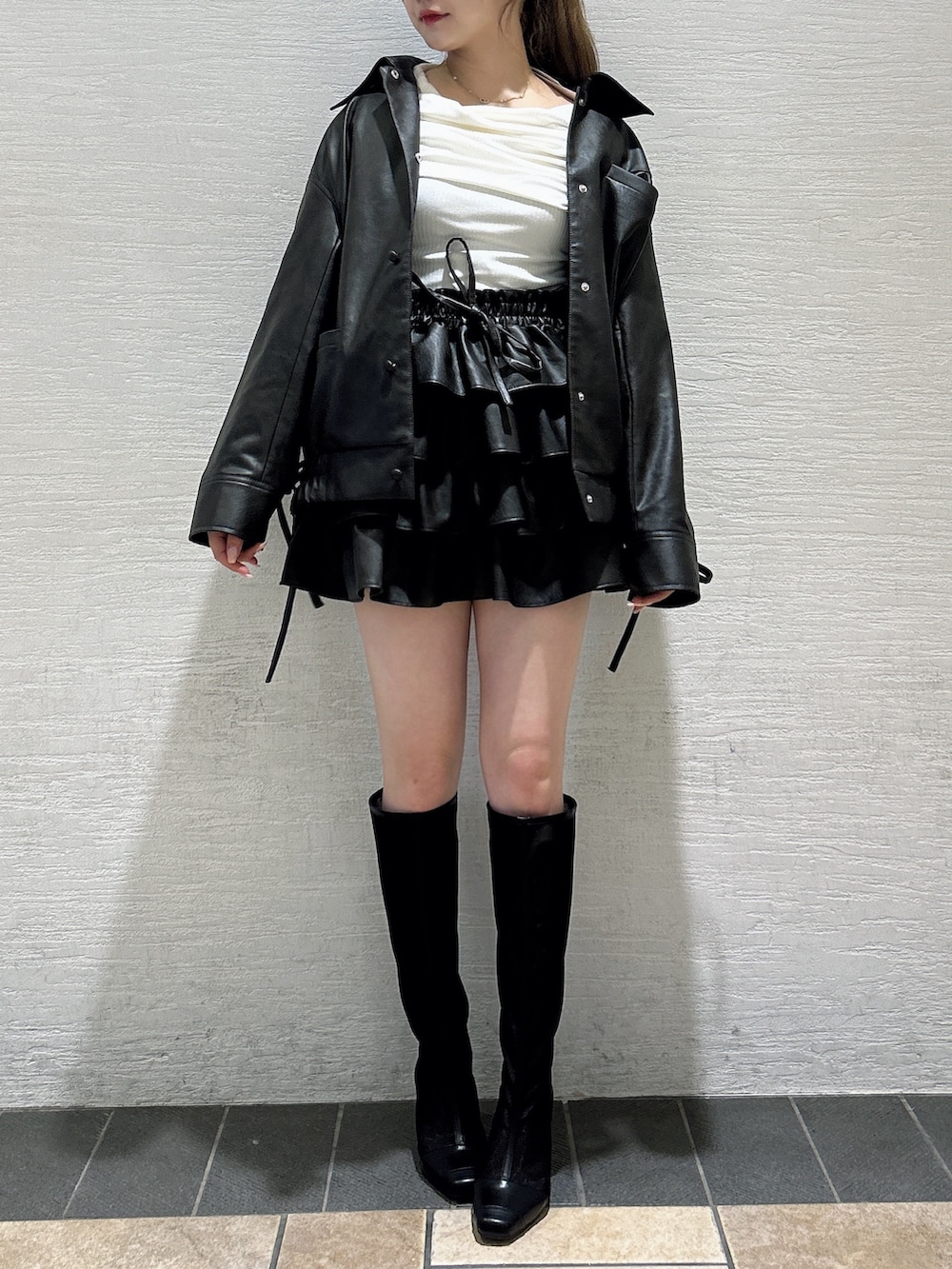 ブラウン系のスカート、ブラウン系のブルゾン、ホワイト系のTシャツ/カットソーを着用したレディースの秋コーディネートの3枚目の写真