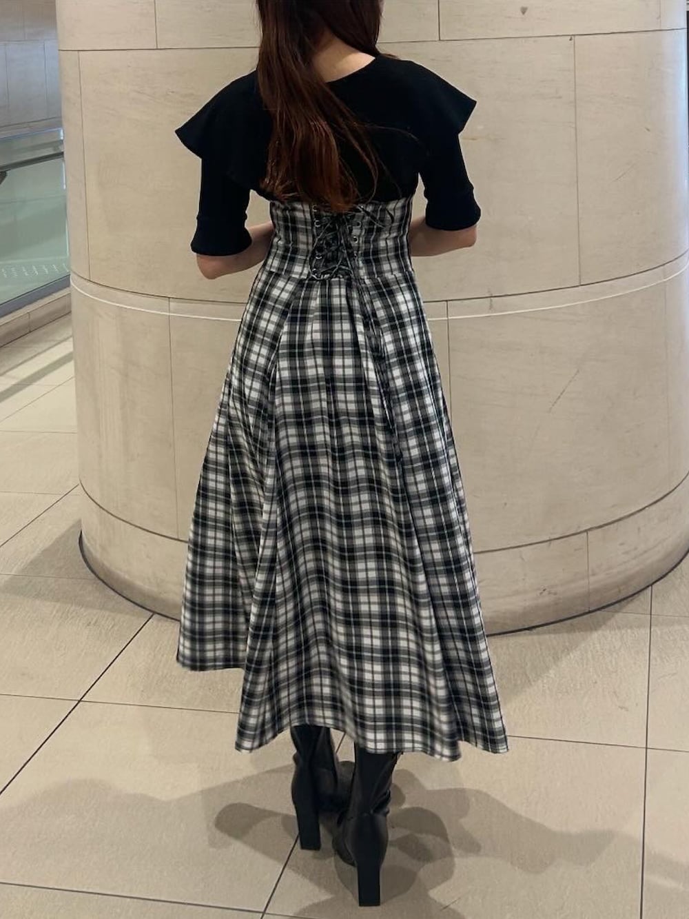 ブラック系のワンピース、ブラック系のブーツを着用したレディースの春コーディネートの4枚目の写真