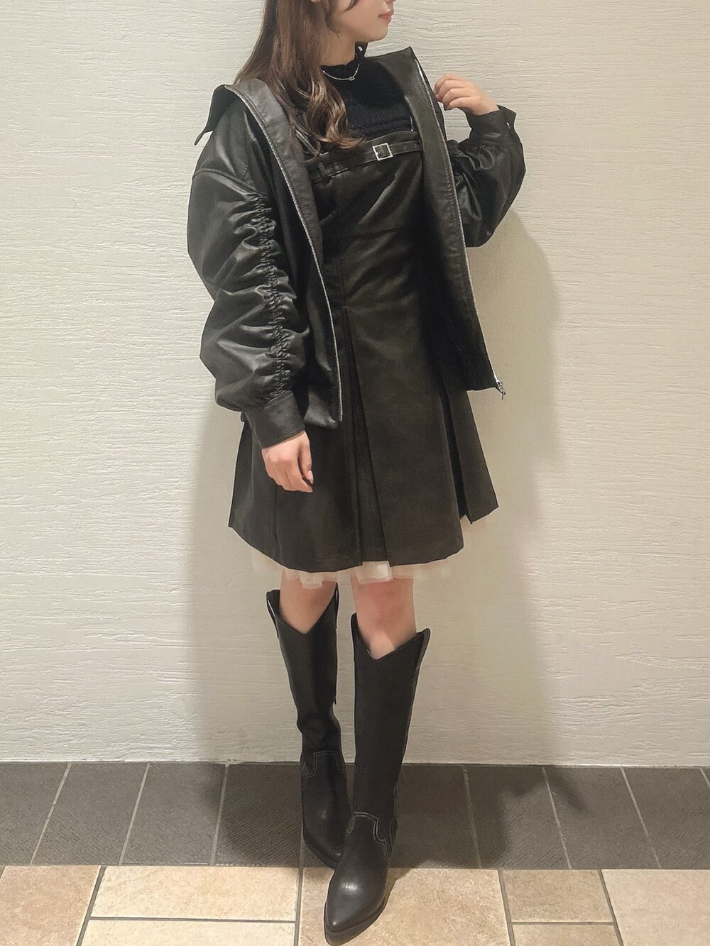 ブラウン系のワンピース、ブラック系のニット/セーター、その他のブーツを着用したレディースの冬コーディネートの6枚目の写真