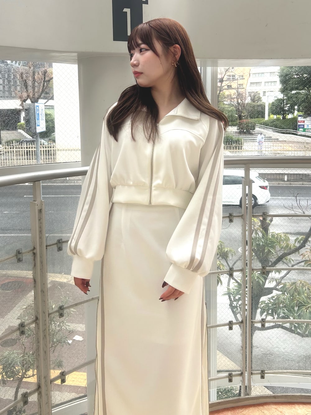 ホワイト系のその他アウター、ホワイト系のスカート、ブラック系のブーツを着用したレディースの春コーディネートの4枚目の写真