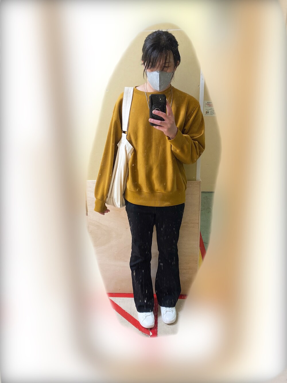 イエロー系のスウェット、ブラック系のデニムパンツ、ホワイト系のスニーカーを着用したメンズの秋コーディネートの3枚目の写真