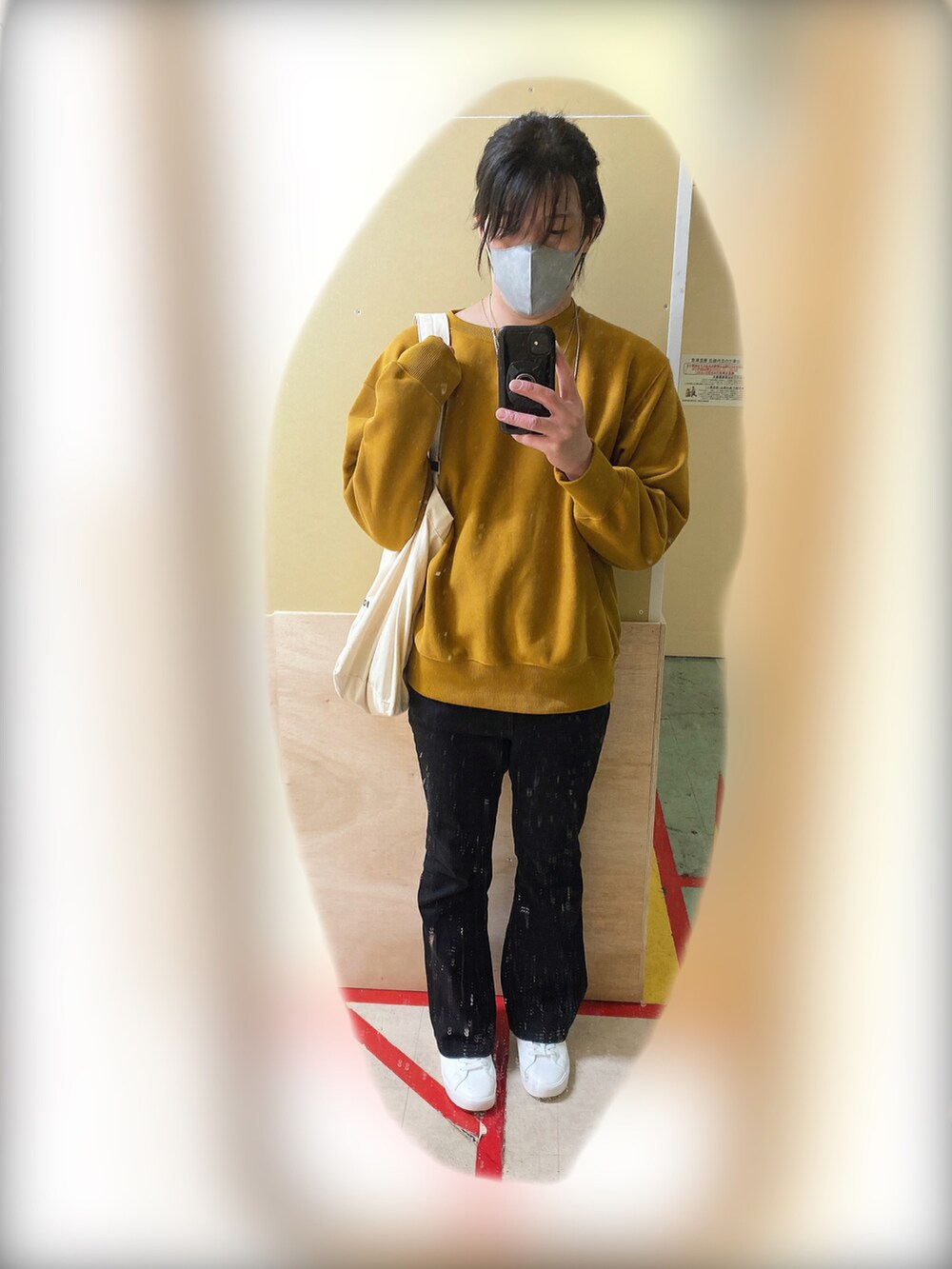 イエロー系のスウェット、ブラック系のデニムパンツ、ホワイト系のスニーカーを着用したメンズの秋コーディネートの2枚目の写真