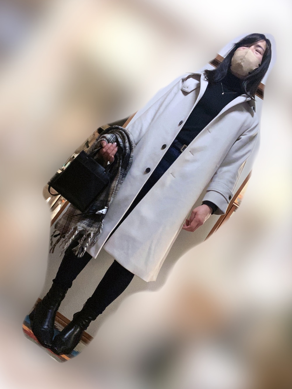 ホワイト系のステンカラーコート、ブラック系のニット/セーター、ブルー系のデニムパンツを着用したメンズの冬コーディネートの2枚目の写真