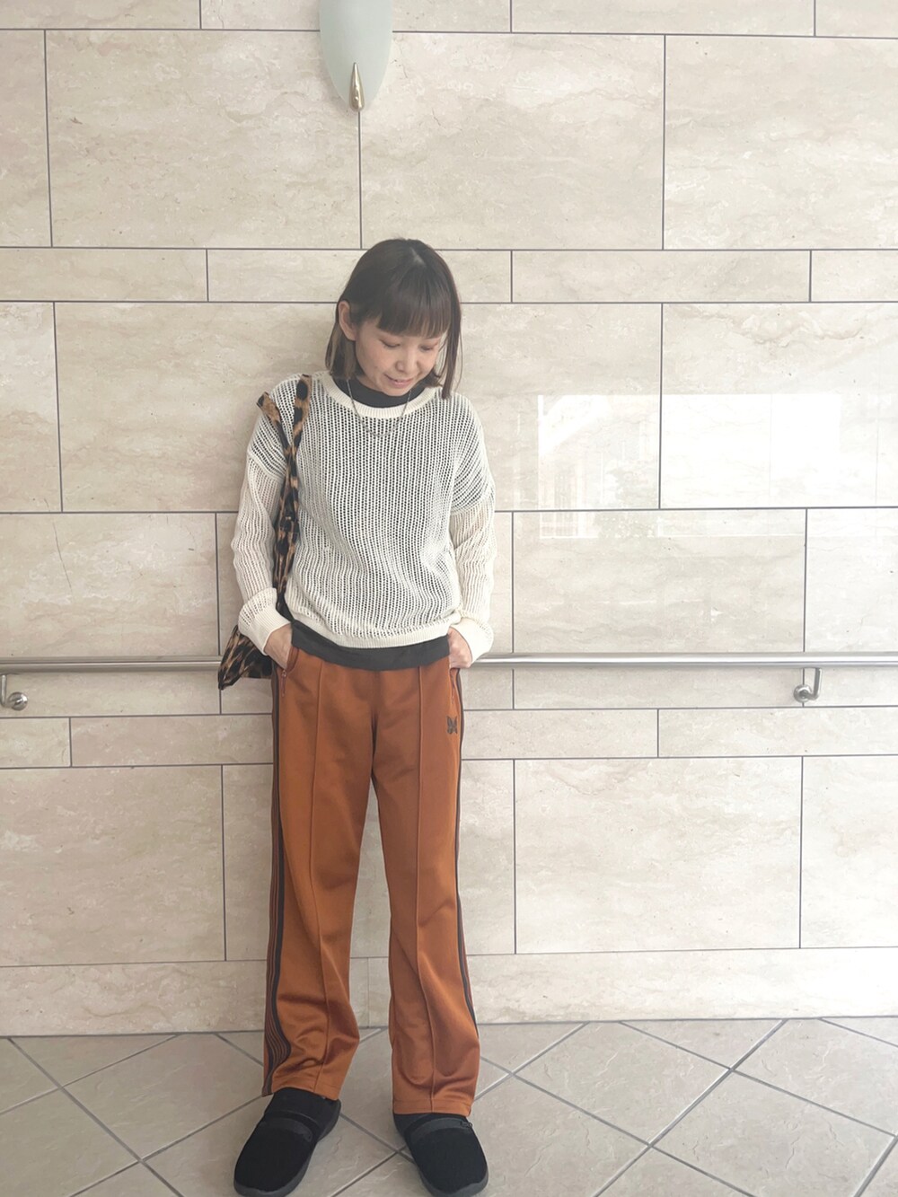 オレンジ系のパンツ、ブラック系のスリッポン、その他のトートバッグを着用したレディースの冬コーディネートの2枚目の写真