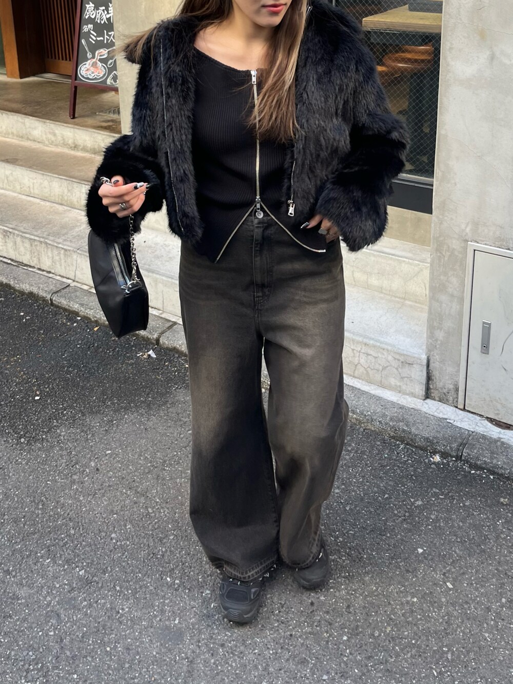 ブラック系のデニムパンツ、ブラック系のニット/セーター、ブラック系のムートンコートを着用したレディースの冬コーディネートの2枚目の写真