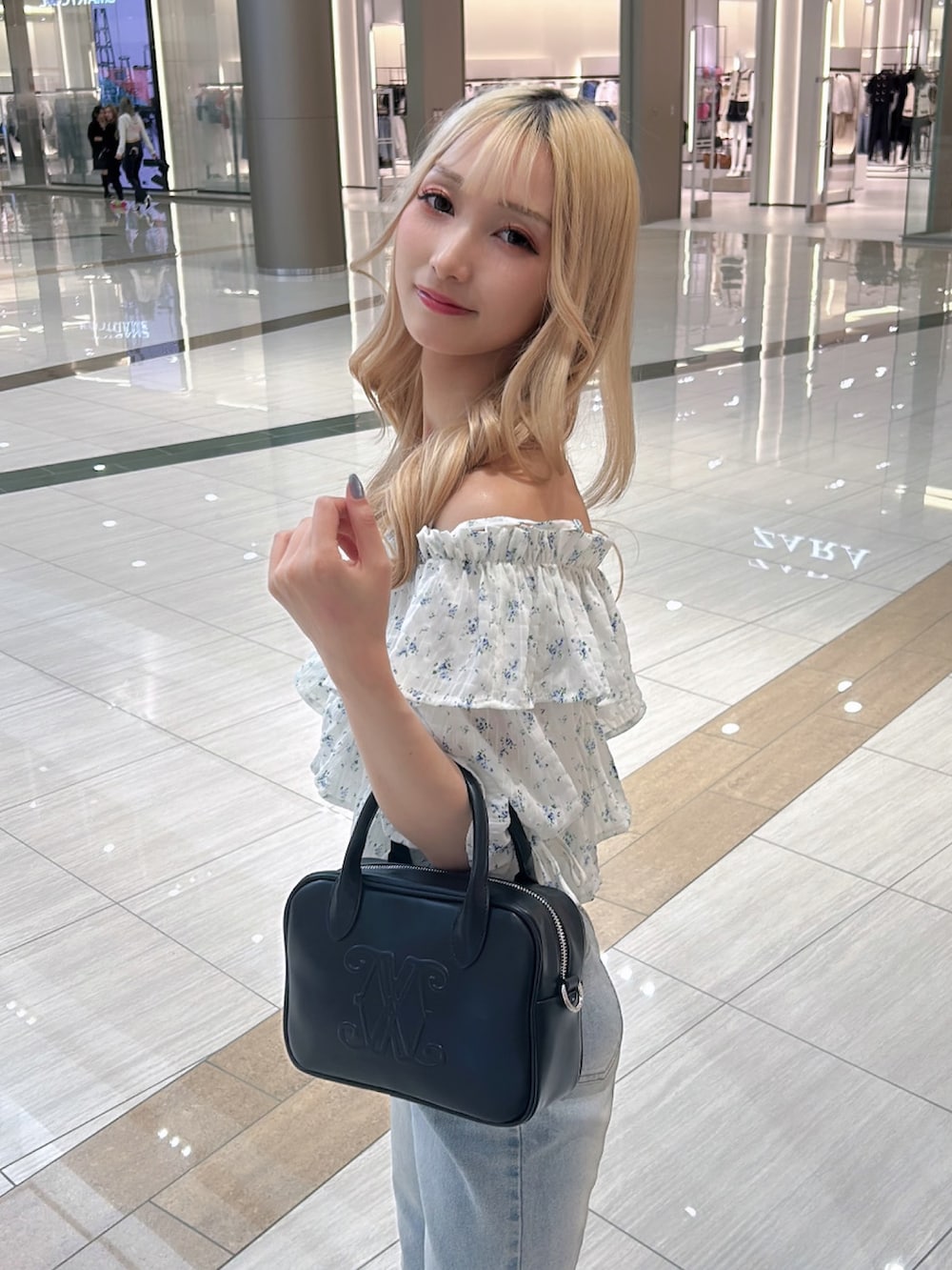 ホワイト系のシャツ/ブラウス、ブラック系のハンドバッグを着用したレディースの春コーディネートの3枚目の写真
