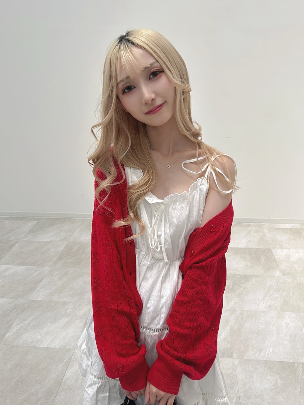 ホワイト系のワンピース、レッド系のカーディガン/ボレロ、グレー系のデニムパンツを着用したレディースの春コーディネートの4枚目の写真
