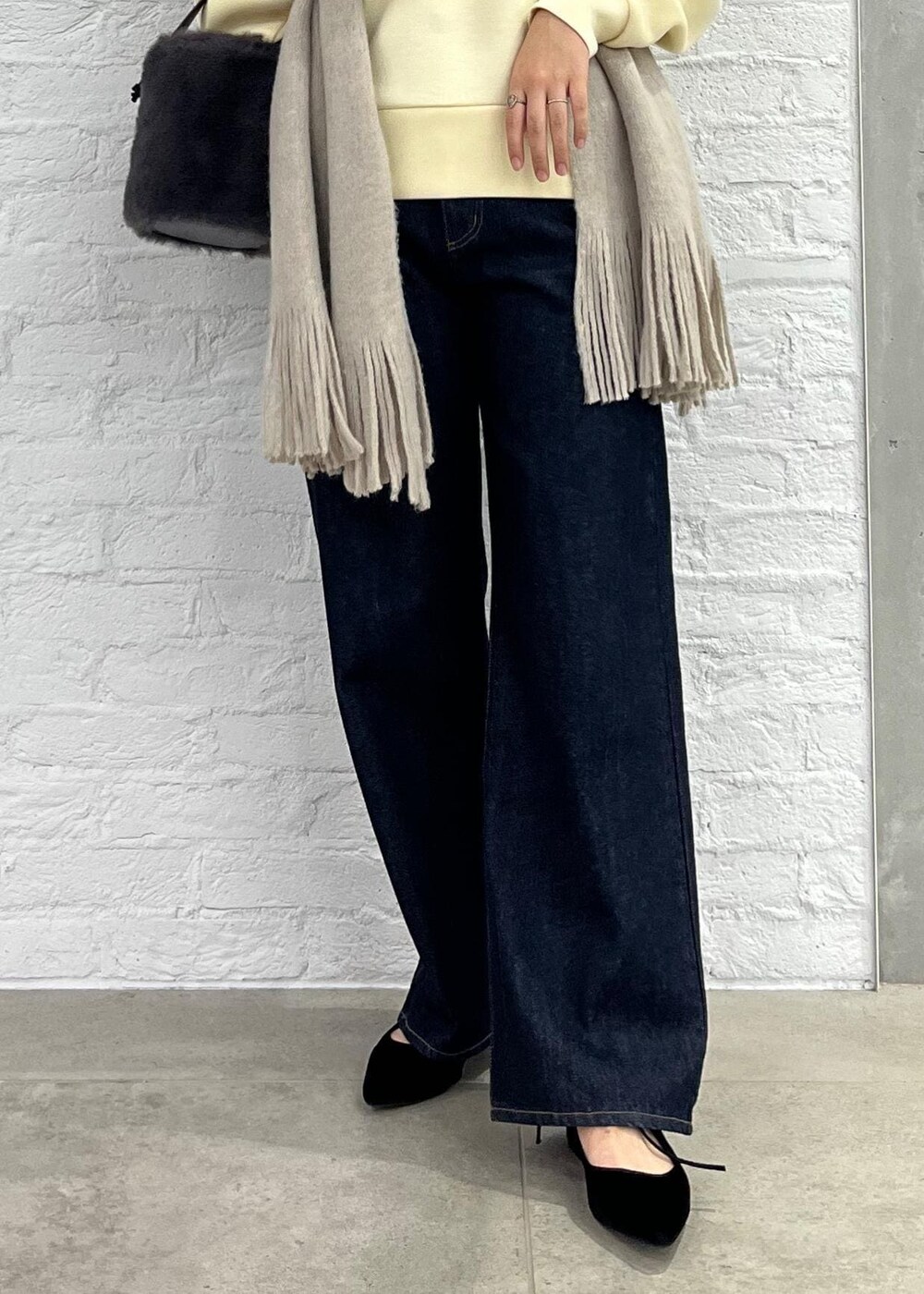 ブルー系のデニムパンツ、グレー系のショルダーバッグ、ベージュ系のその他トップスを着用したレディースの秋コーディネートの7枚目の写真