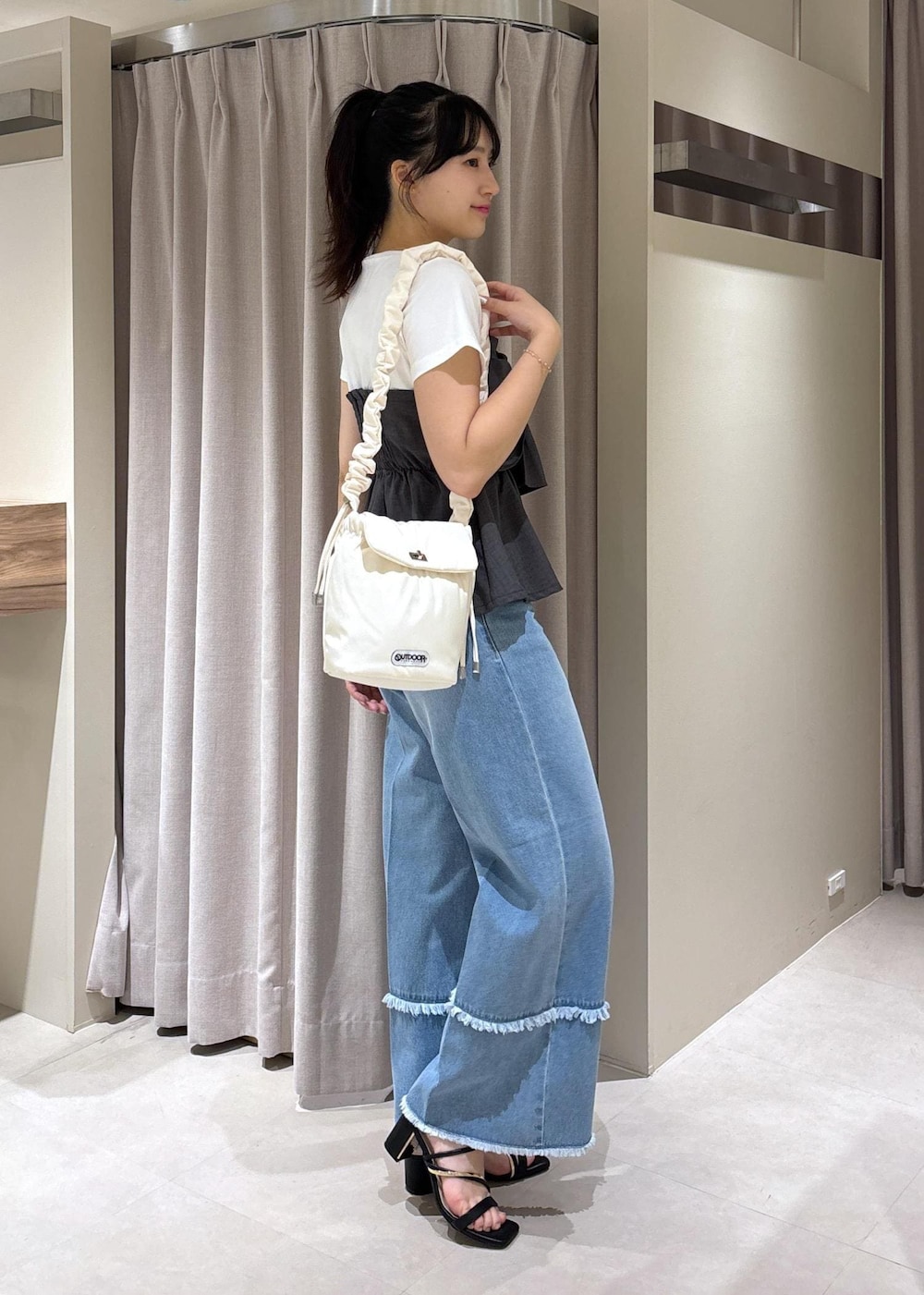 ブラック系のサンダル、ブルー系のデニムパンツ、グレー系のTシャツ/カットソーを着用したレディースの夏コーディネートの2枚目の写真