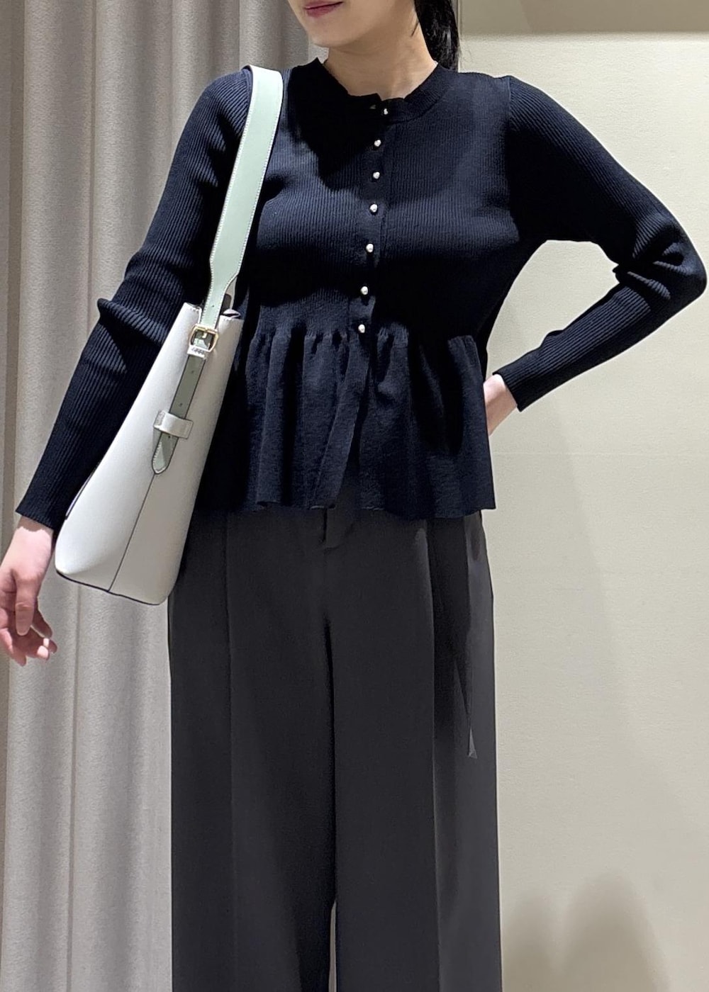 グレー系のトートバッグ、ブラック系のパンプス、ブルー系のカーディガン/ボレロを着用したレディースの春コーディネートの4枚目の写真