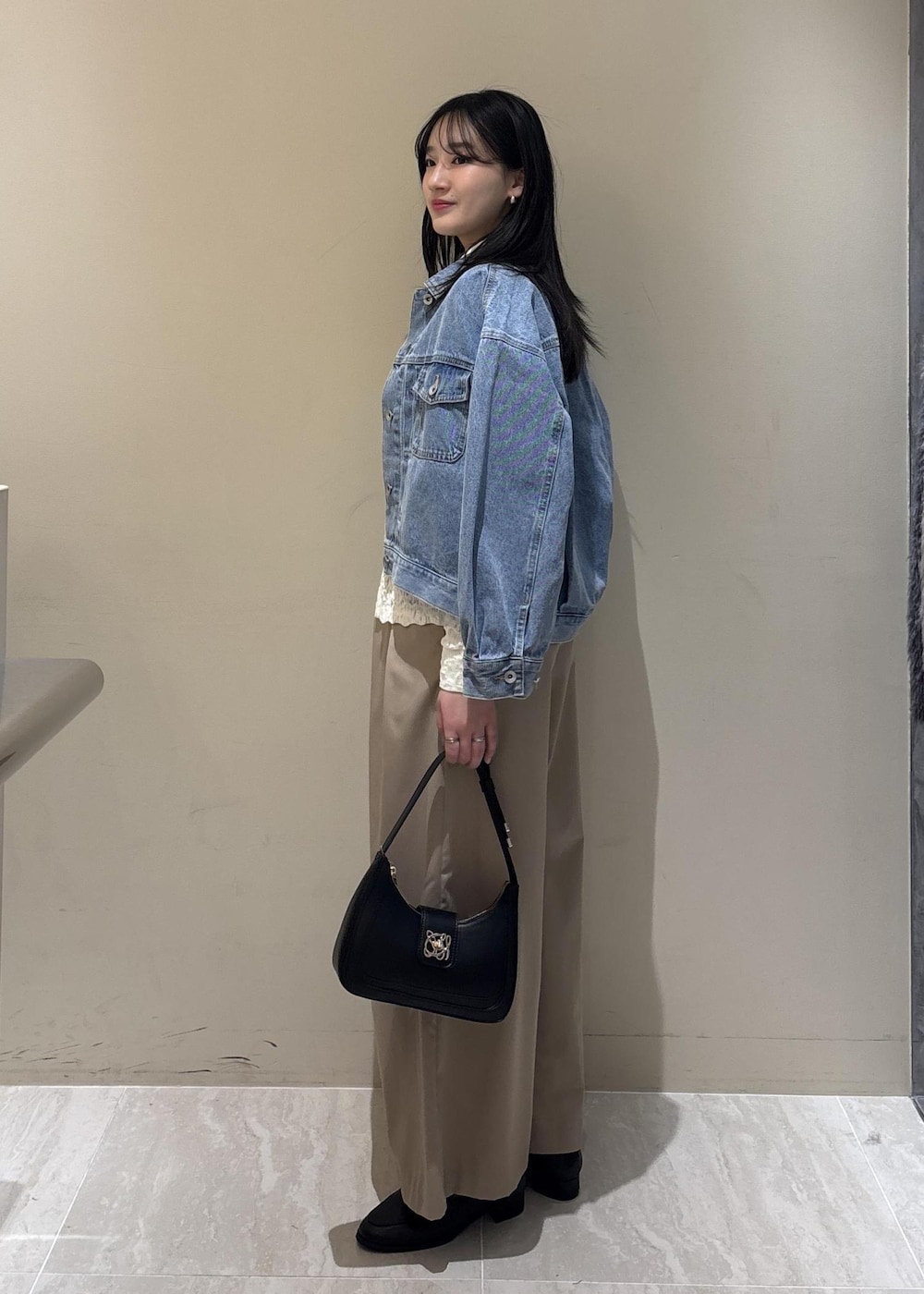 ブラック系のショルダーバッグ、ブラック系のローファー、ホワイト系のシャツ/ブラウスを着用したレディースの冬コーディネートの2枚目の写真