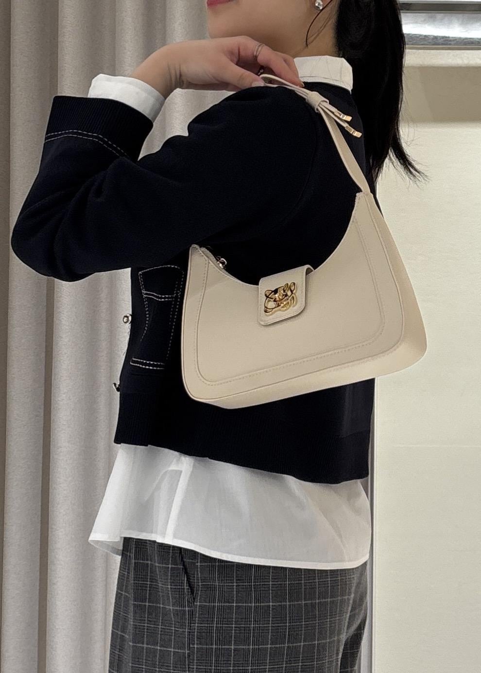 グレー系のその他パンツ、ホワイト系のショルダーバッグ、ブラック系のローファーを着用したレディースの冬コーディネートの8枚目の写真